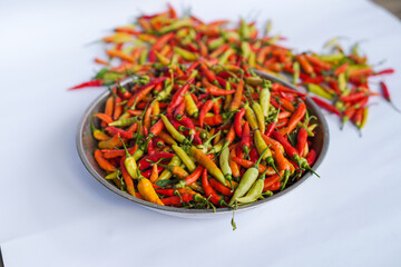 Abundance of fresh chilies harvest ready for sale on a white background