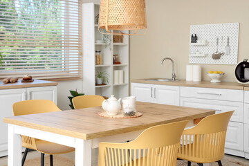 Interior of stylish kitchen with dining table, white counters and peg board