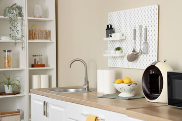 Interior of stylish kitchen with white counters and peg board. Closeup