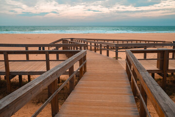 Obraz premium Ocean Beach in Portugal with Wooden Boardwalks. Scenic wooden pathways stretch along the coastline, inviting peaceful walks and endless exploration