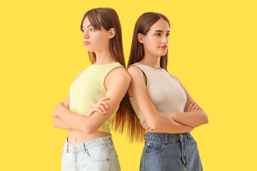Fototapeta premium Beautiful young women after quarrel on yellow background