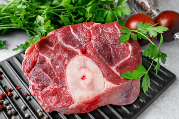 Fresh beef osabuko with brightly coloured herbs in a rustic kitchen interior for culinary inspiration