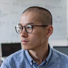 A technology person with glasses looking to the side