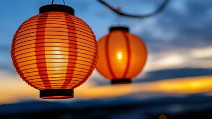 Obraz premium Two vibrant lanterns glow warmly against a fading sky, creating a welcoming atmosphere for evening festivities by the riverside. The sunset enhances the scene