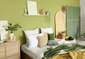 Interior of stylish bedroom with plants, shelf and bed