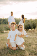 Fototapeta premium Happy male and female playing with children outside