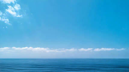 Fototapeta premium Deep Blue Ocean Meets Azure Sky with Low Scattered Clouds and a Clear Horizon on a Calm Day