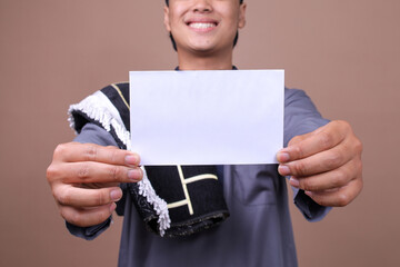 Selective Focus Of Envelope Held By Young Muslim Man On Beige Background