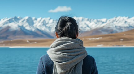 Fototapeta premium Traveler Admiring Snow-Capped Mountains by a Turquoise Lake