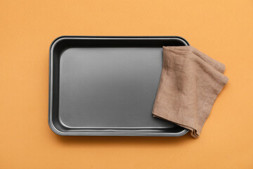 Baking tray and towel on beige background. Top view