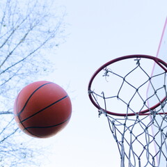 A basketball flies into a basket on a sports court outside