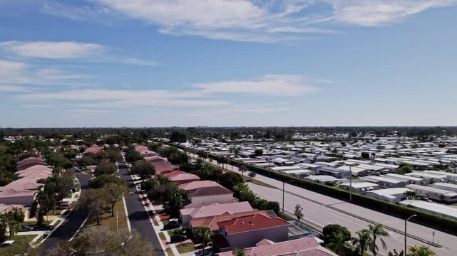 Aerial: West Palm Beach residential zone during the day with white houses, push in in drone shot, USA