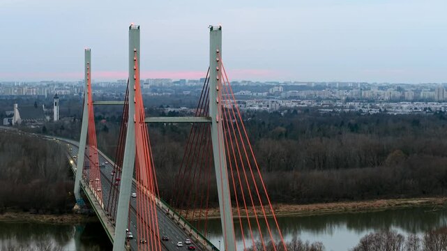 Siekierkowski bridge in warsaw at sunset, with cars and cityscape in the distance, aerial view