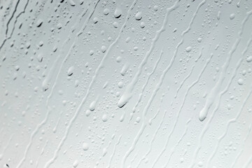 Water drops on light glass surface, top view