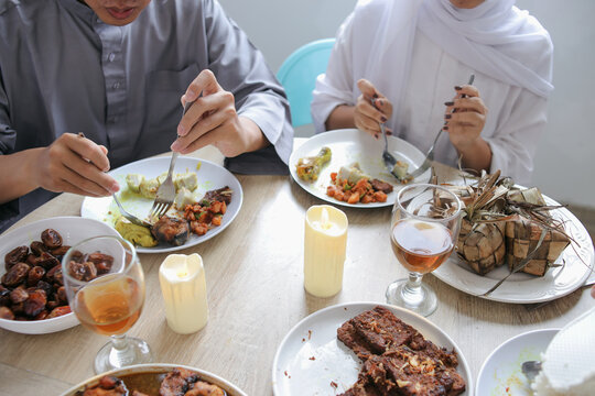 Close-up Muslim Couple Hands Enjoy Eating Special Food Together At Dining Room Celebrating Eid