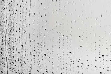 Water drops on light grey glass surface, top view