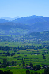 Breathtaking green valley opening up to blue mountains in rural landscape