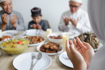Close Up Of Hands Praying Together With Family Before Eating Special Food on Eid Al Fitr Moment