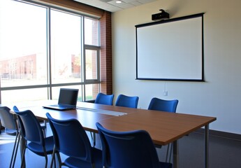 A conference room with a white board and a laptop on a table