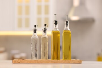 Bottles of salad dressings on white table in kitchen