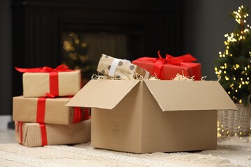 Parcel with gift boxes on floor in room decorated for Christmas. Bokeh effect