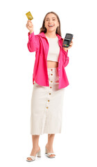 Young woman with credit card and payment terminal on white background
