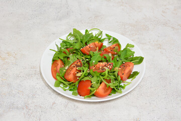 Arugula and Tomato Salad on the white plate
