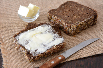 Buttered Dark Bread slice of bread on burlap texture knife