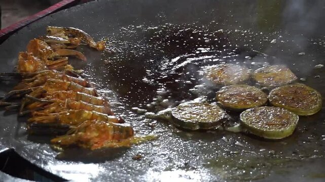 Hilsha fish is fried in a big pan along with shrimp and eggplant, Hilsha Fish and shrimp Simmering in mustard oil, traditional Bengali style fried hilsa and eggplant