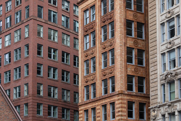 Historic and modern buildings in downtown Boston featuring intricate facades, brickwork, and Art Deco details. The urban architecture highlights the city's rich architectural heritage and design style