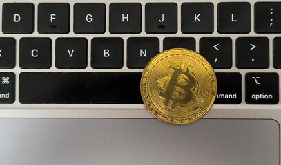 Gold bitcoin coins, laptop keyboard, flash drive close up. Cryptocurrency business concept