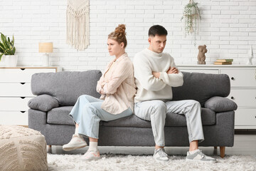 Upset young couple after quarrel at home