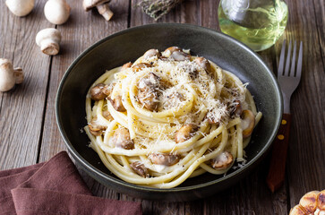Bucatini pasta in creamy sauce with mushrooms and cheese. Vegetarian food. Italian cuisine.