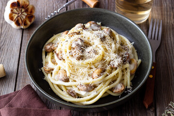 Bucatini pasta in creamy sauce with mushrooms and cheese. Vegetarian food. Italian cuisine.