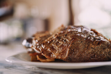 Roast beef with spices lies on a plate on a table