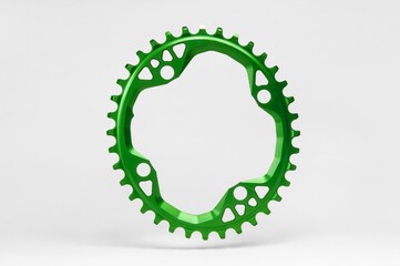 Green oval bicycle chainring against white isolated background, hanged in the air, floating above...