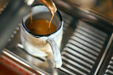 Close up of coffee machine pouring espresso in cafe