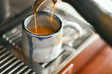 Close up of coffee machine pouring espresso in cafe