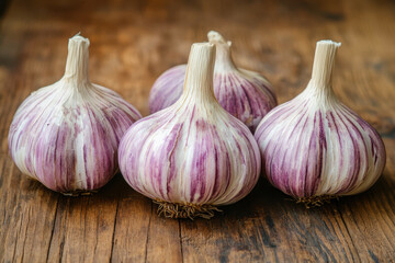 Three garlic bulbs on a wooden table, casting soft shadows.