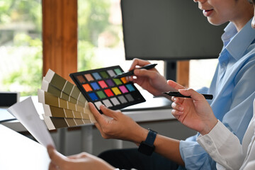 A Close-up of a creative team evaluates color palettes and design samples, discussing the best...