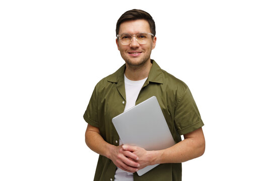 Young man smiling while holding a laptop in a studio setting during a bright morning session