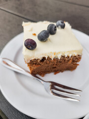 Delicious carrot cake with cream cheese frosting and blueberries in prague