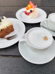 Enjoying cappuccino with  Carrot, meringue Pavlova cakes on a table in prague