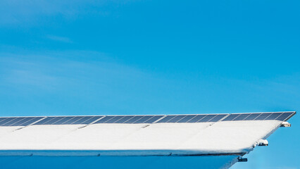 Solar panels covered in snow gleam under the winter sun, generating sustainable, clean energy.
