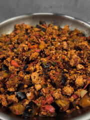 Ground Turkey meat with eggplant and peppers cooking in stainless steel pan