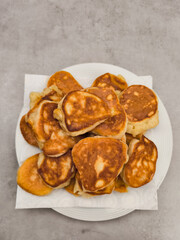 Freshly cooked pancakes resting on a white plate