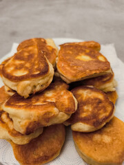 Delicious golden pancakes stacked on white plate draining excess oil