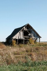 Obraz premium Abandoned wooden barn in field