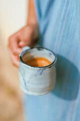hand holding a cup of espresso shot..