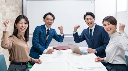 ガッツポーズをするビジネスマン四人